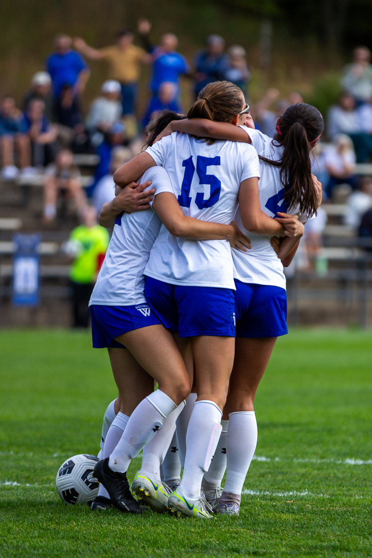 Several soccer teammates embrace each other.