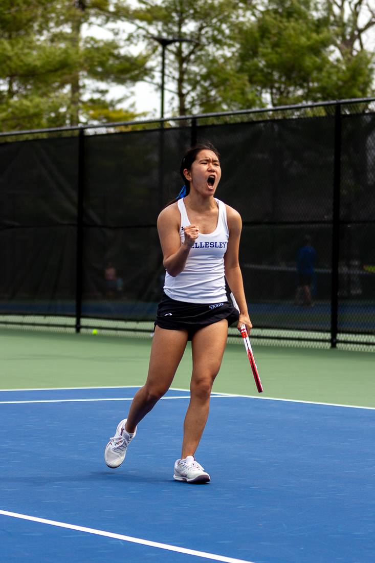 A tennis player yells in celebration.